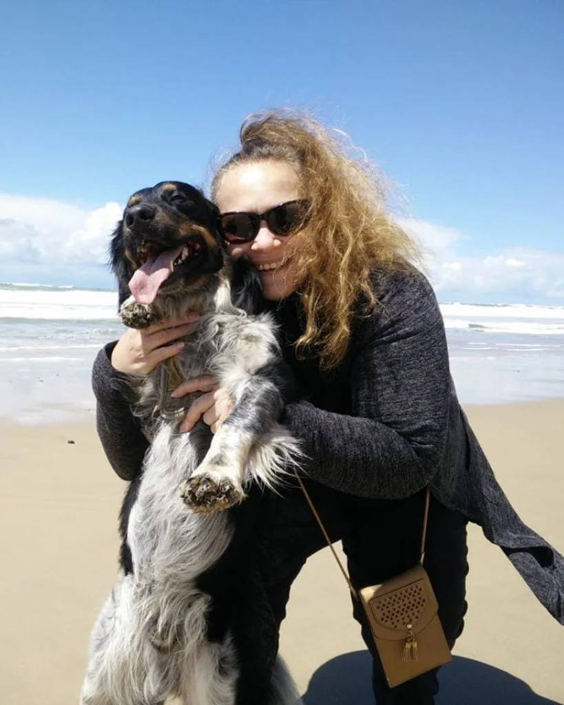 Elke Meise lachend met haar hond op het strand