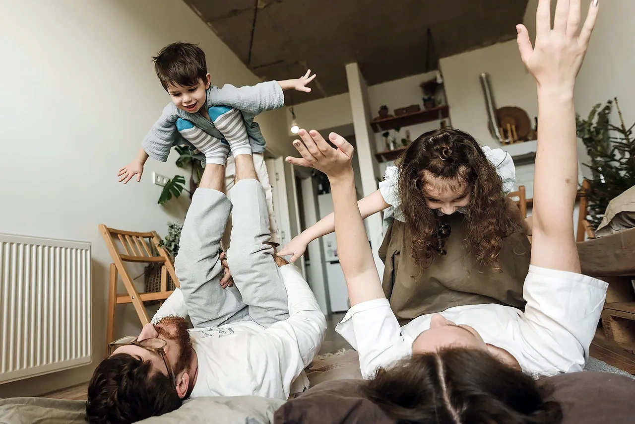 Parents playing with their children on the living room floor